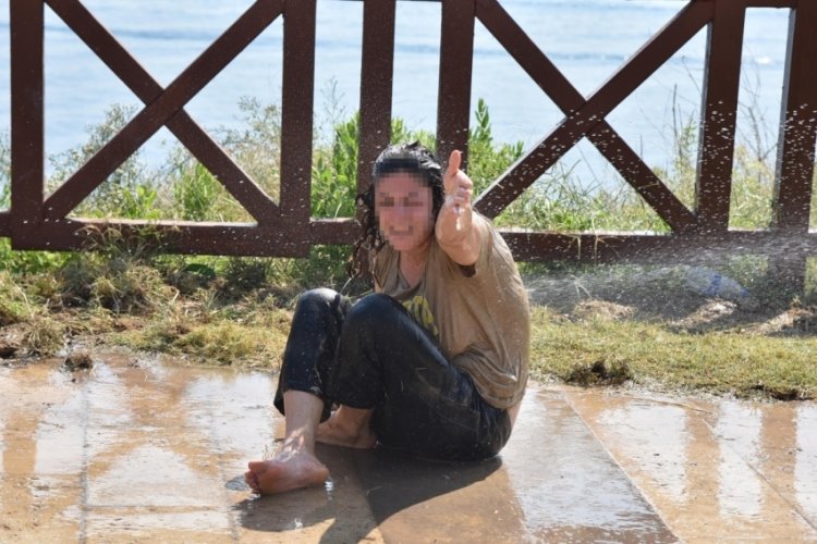 Antalya'da parkta yerde yatan kadın, fıskiye ile temizlendi