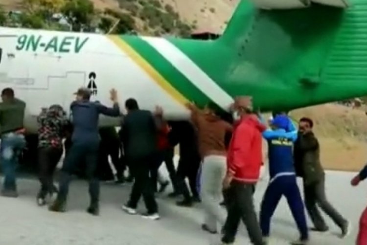 Nepal'de lastiği patlayan u&ccedil;ağı ittiler