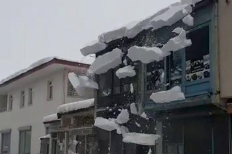 Ağrı'da &ccedil;atıda biriken kar k&uuml;tlesi caddeye d&uuml;şt&uuml;