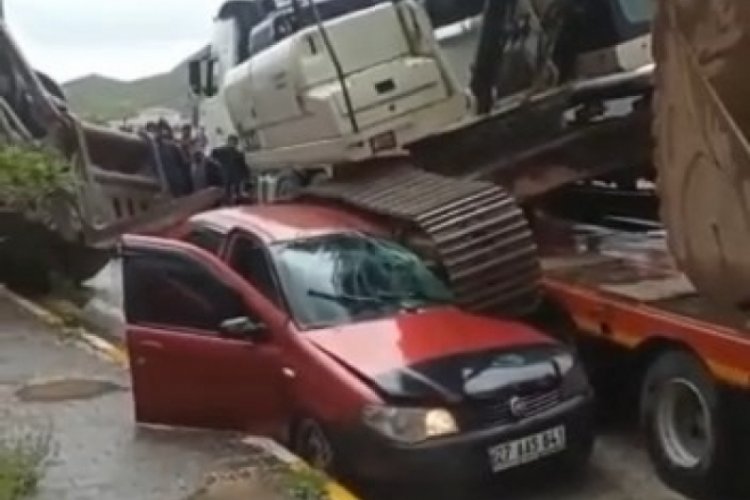 Tırın &uuml;st&uuml;ndeki iş makinesi aracın &uuml;st&uuml;ne d&uuml;şt&uuml;