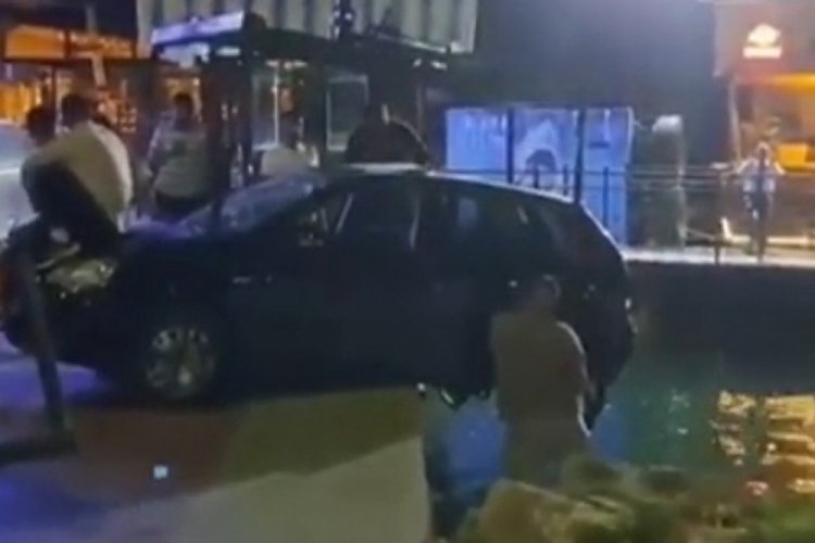 Askıda kalan otomobilin denize d&uuml;şmemesi i&ccedil;in kaputa oturup &ccedil;ekiciyi beklediler