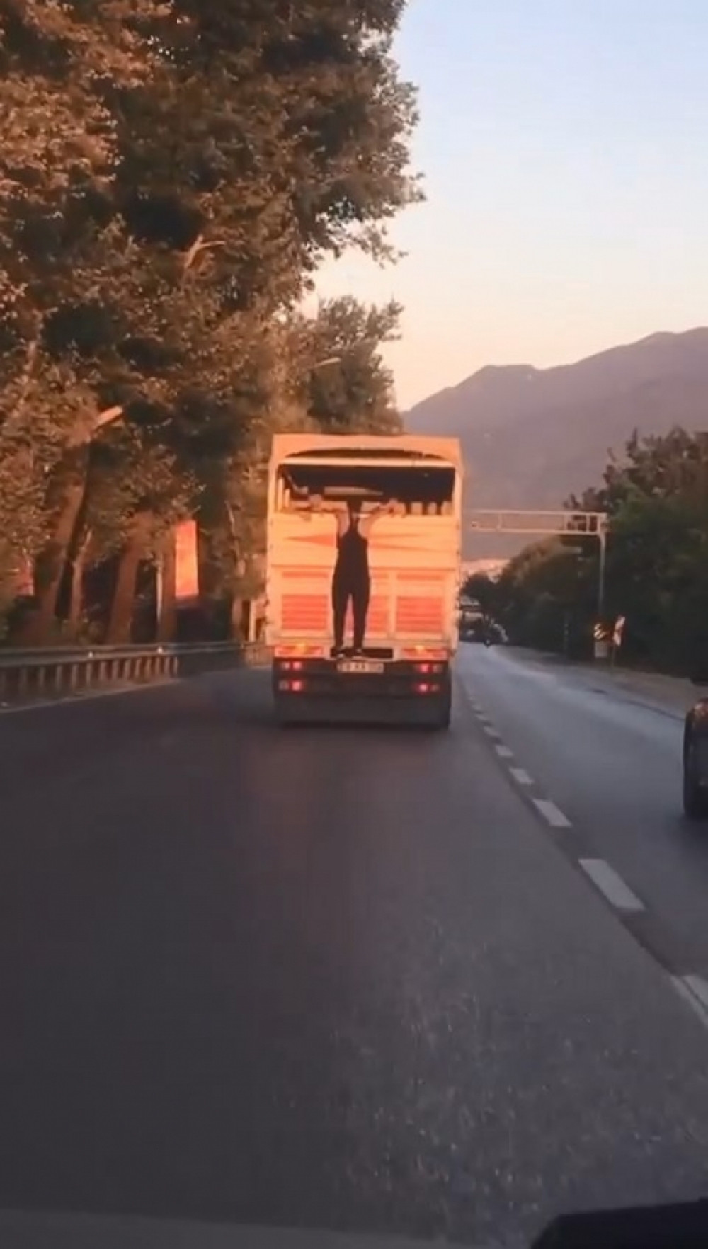 Bursa'da kamyon kasasının kapağına tutundu: Canını ve trafiği yok saydı
