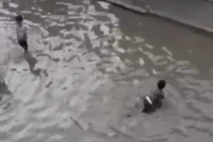 İzmir'de biriken yağmur suyunda &ccedil;ocuklar y&uuml;zd&uuml;