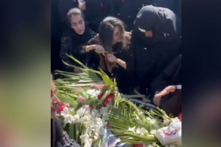İran'da &ouml;ld&uuml;r&uuml;len kardeşinin mezarı başında sa&ccedil;larını kesti