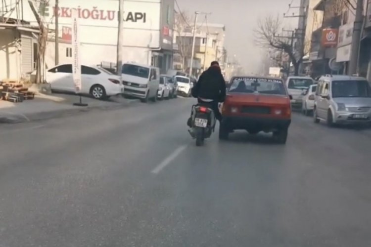 Bursa'da bozulan otomobilini motosiklet ile iterek tamire g&ouml;t&uuml;rd&uuml;
