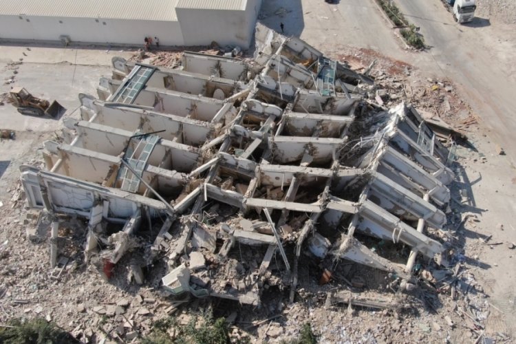 Hatay'da operat&ouml;re mezar olan iş makinesi, 8 katlı binanın enkazından tanınmaz hale geldi