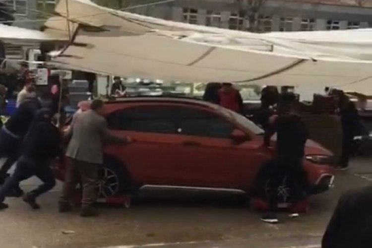 Bursa'da otomobilin s&uuml;r&uuml;c&uuml;s&uuml; gelmeyince, pazarcılar meseleyi paletle &ccedil;&ouml;zd&uuml;
