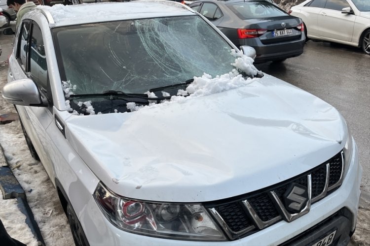 Erzurum'da &ccedil;atıdan d&uuml;şen kar k&uuml;tleleri bir otomobilde hasara yol a&ccedil;tı