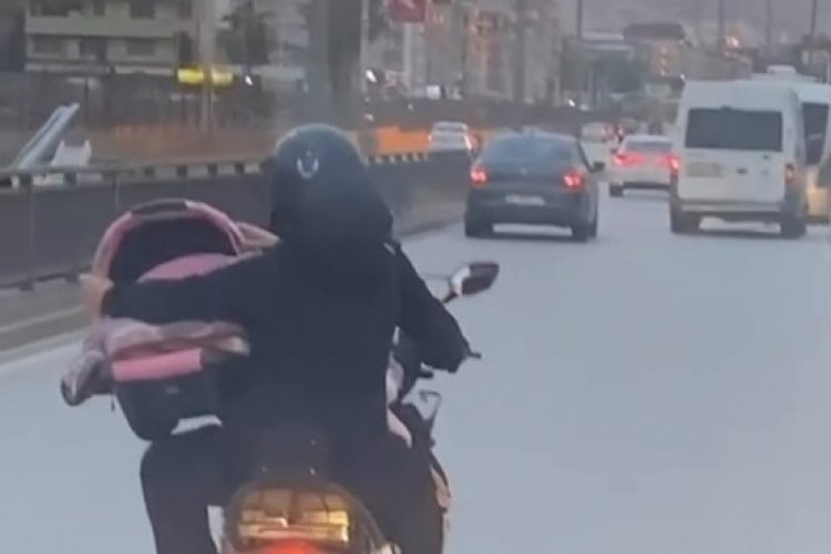 Bursa'da tehlikeli anlar! Bebeği b&ouml;yle taşıdı