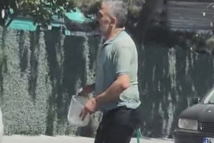 Sıcaktan bunaldı: Hortumla hem kendini hem de aracını yıkadı