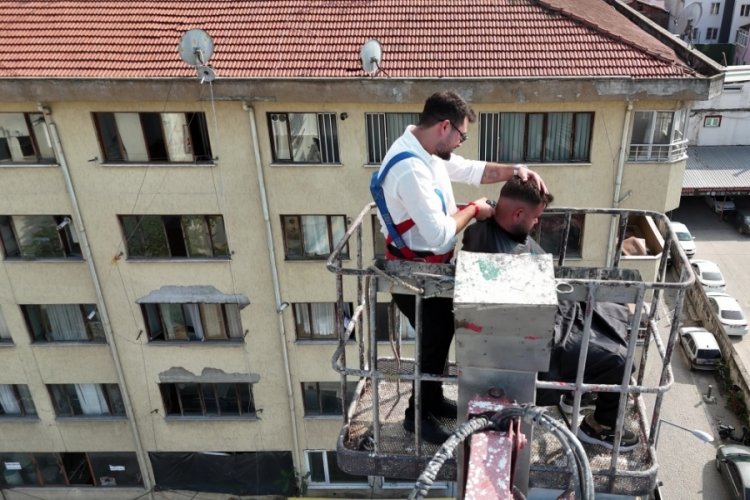 15 yıllık berber yeni açtığı dükkanının ilk tıraşını gökyüzünde yaptı