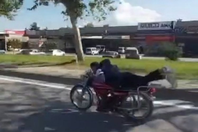 Plakasız motosiklet sürücüsü ellerini bırakıp motorun üzerine yatarak ilerledi