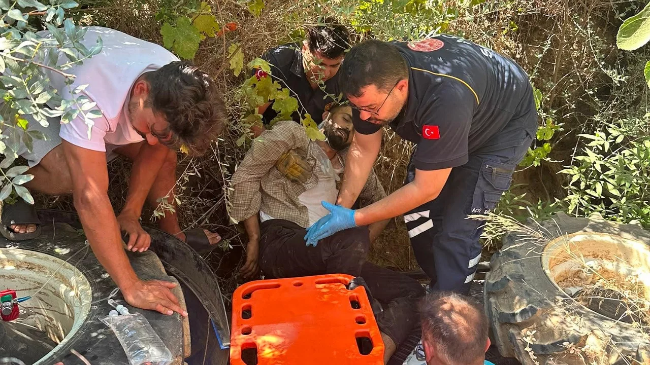 Devrilen traktörün altındaki sürücüyü itfaiye ekipleri kurtardı