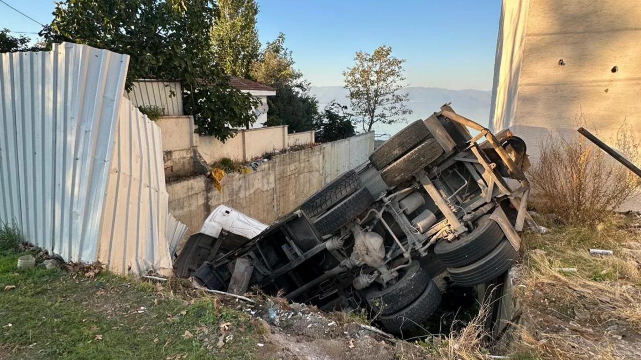 Bursa'da köpeğe çarpmamak için manevra yapan hafriyat kamyonu bahçeye devrildi!