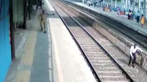 Hindistan'da polis, bir kişiyi trenin altında kalmaktan son anda kurtardı