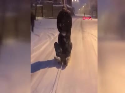 Bursa'da buzlu yolda otomobile bağladıkları kızakla kaydılar