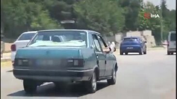 Pes dedirten görüntü! Seyir halindeki otomobilde canını hiçe saydı