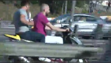 Motosikletlinin arkasında dürüm yerken
